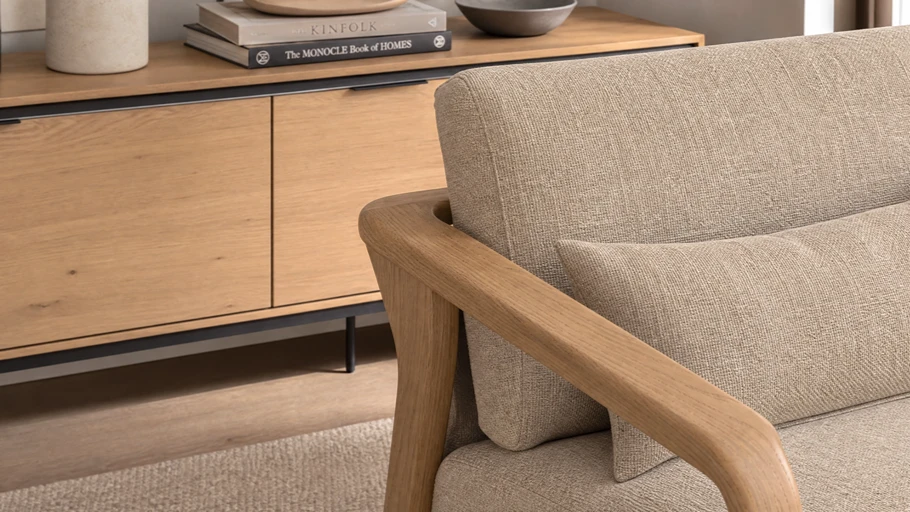 Close-up shot of high-quality modern furniture textures including light oak wood and natural sand-colored linen fabric.